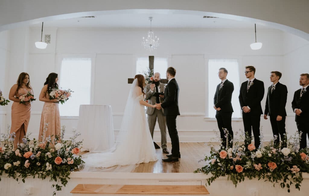Ceremony of a bride and groom officiated in front of a cross