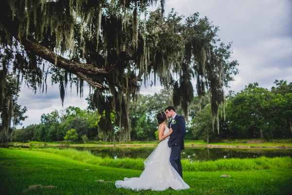 Bride and groom kissing under an oak tree