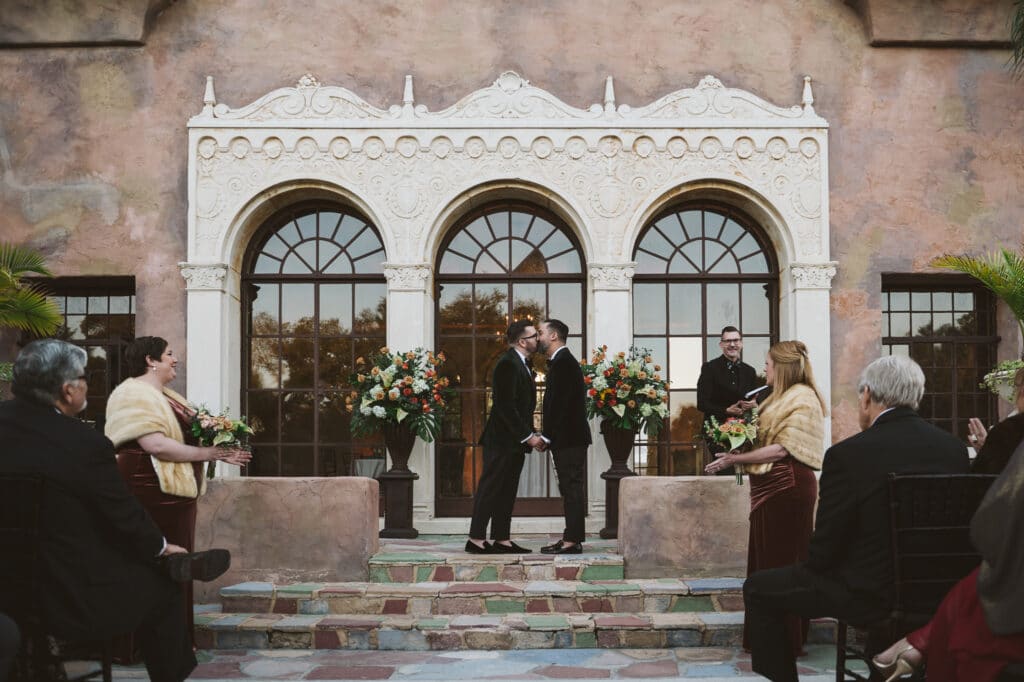 grooms kissing on stone patio photo by Rudy and Marta Photography