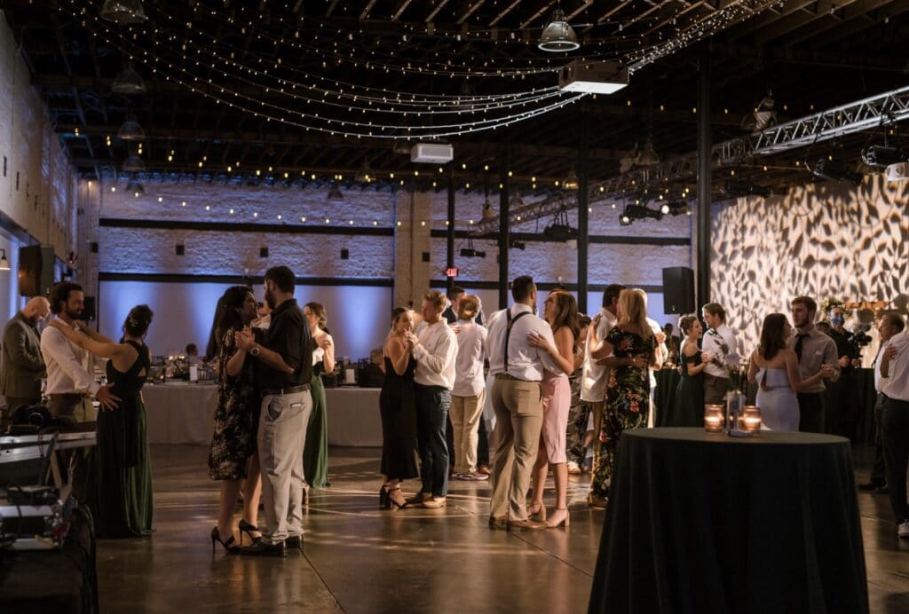 reception with concrete floors and market lights on the dance floor