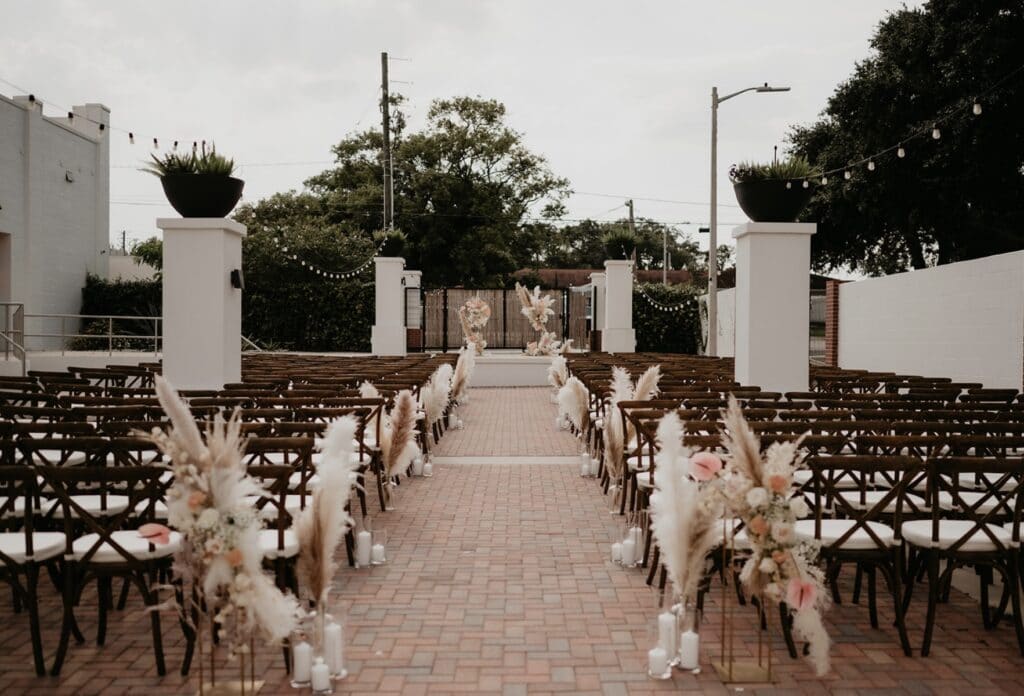 Haus 820 exterior set up for a wedding with white flowers at the end of the rows of seats