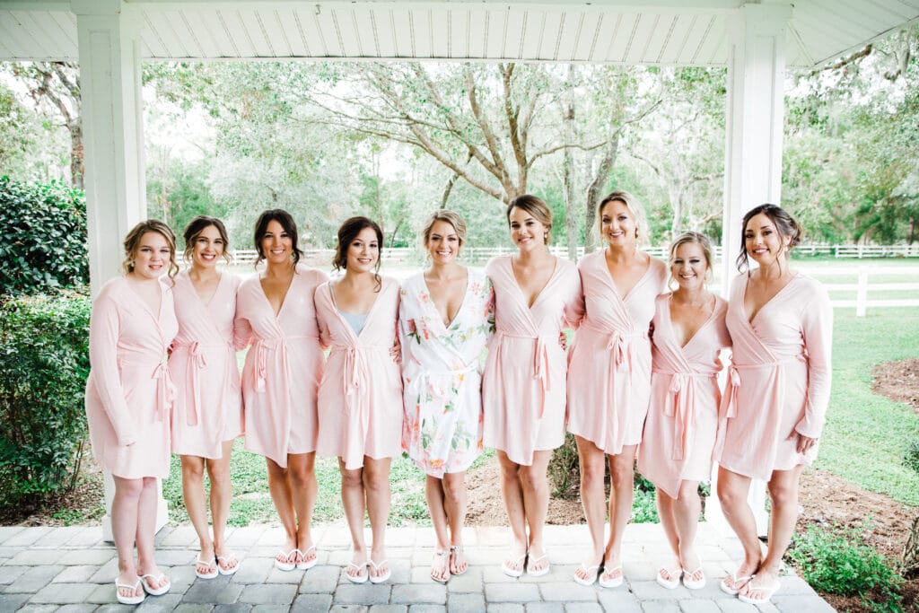 bride and bridesmaids all in pink on patio at Bramble Tree Estate