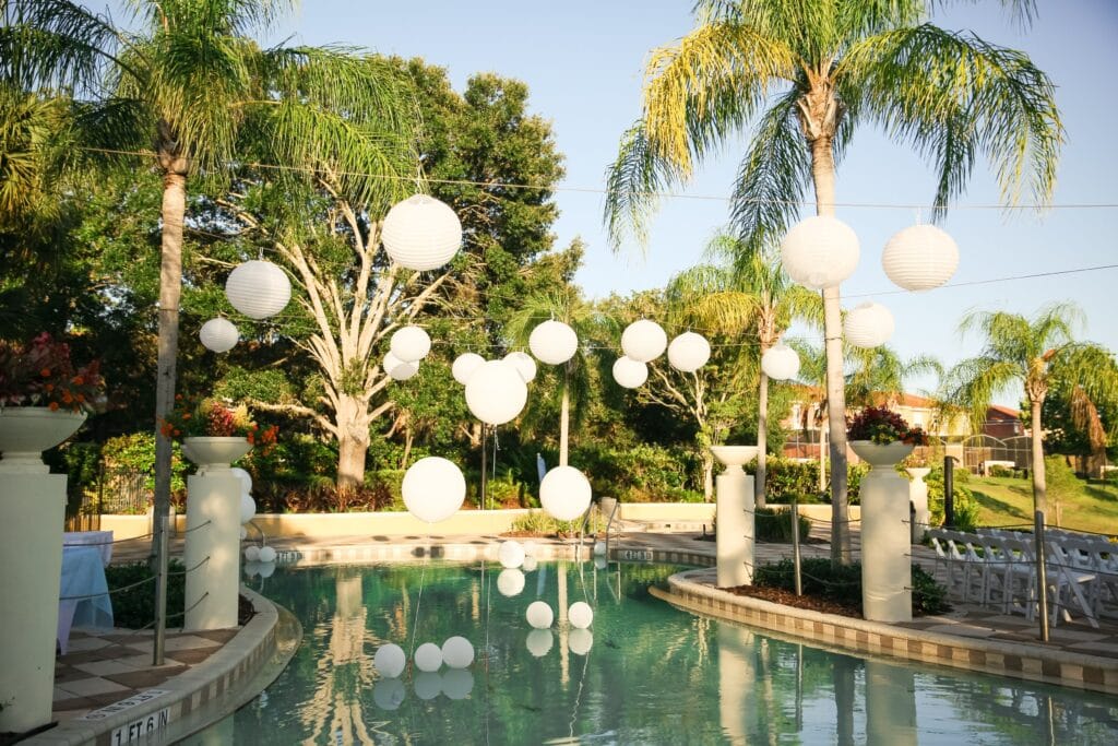 pool with white globes hanging over it and reflected in it with palm trees in the background by Bold Beautiful and Beyond weddings