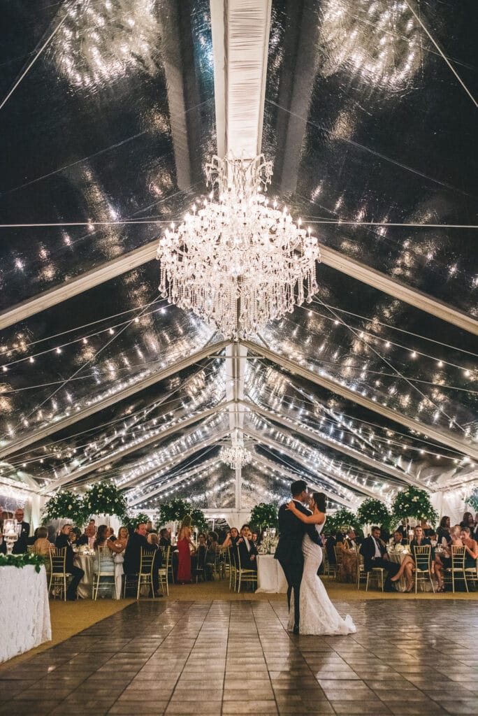 beautifully lit with large chandeliers and market lights first dance photo by Rudy and Marta Photography