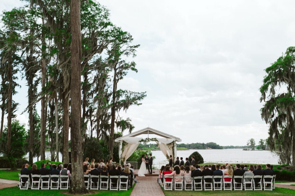 outdoor wedding ceremony with chairs facing a lake photo by Rudy and Marta Photography