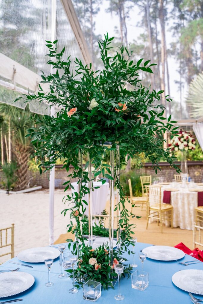 tall greenery centerpiece in large glass vase by Stems in Bloom