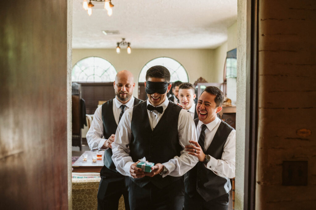 groom blindfolded and being led by groomsmen to see bride for the first time photo by Rudy and Marta Photography