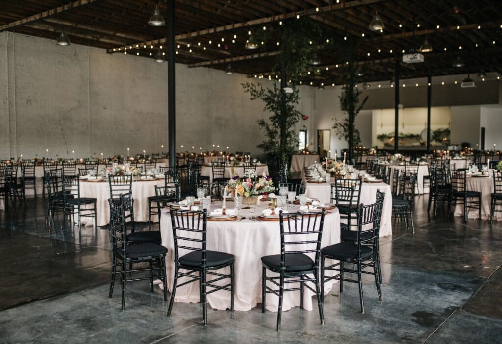 white table linens and black chairs with tall green centerpieces at Haus 820