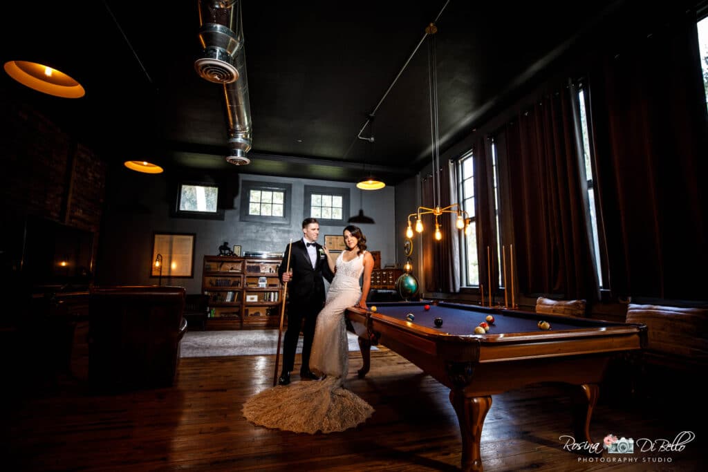 Bride and groom in a rustic parlor with a pool table