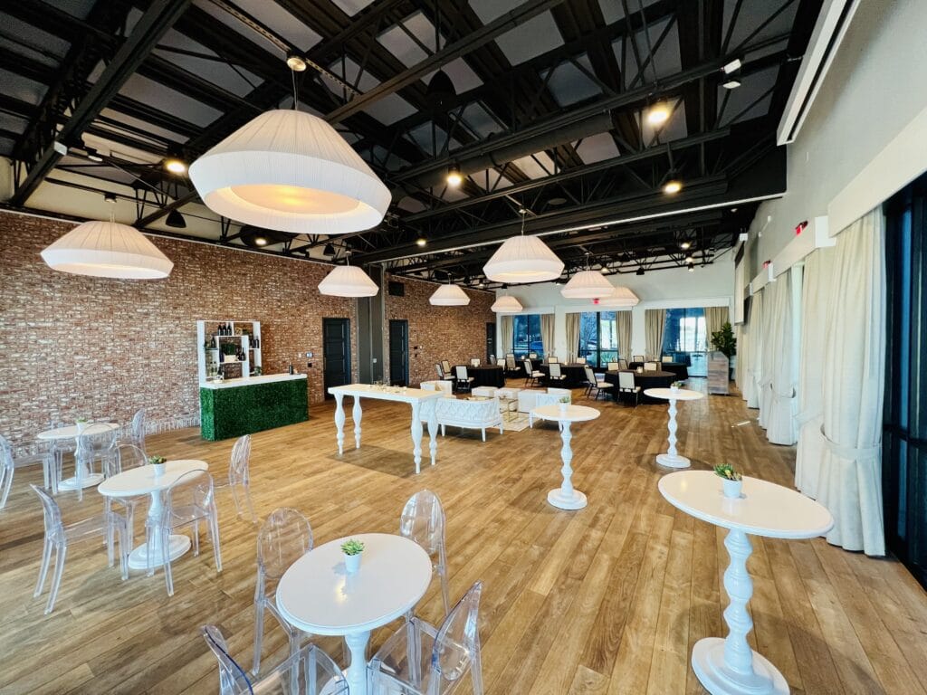 event room with wood floors and white tables