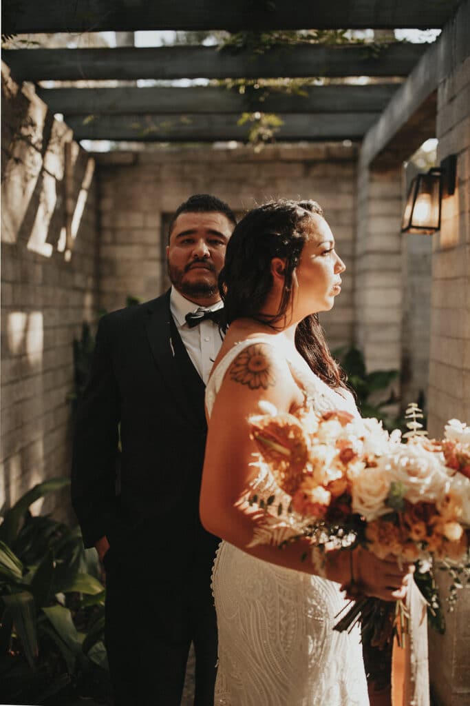 groom looks at bride as sunlight shows her face and bouquet, details by 360 Emotions