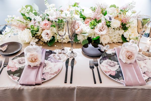 Reception table with pink linens and pink and white roses.