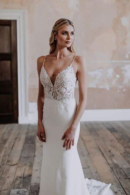 bride in a slip dress with lace and embellished bodice from Enchanted Bride stands in bridal ready room