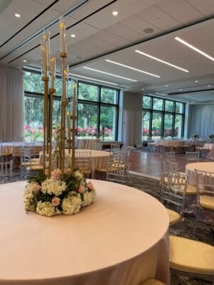 clear chairs and tables draped with pink linens and pink and white floral centerpieces