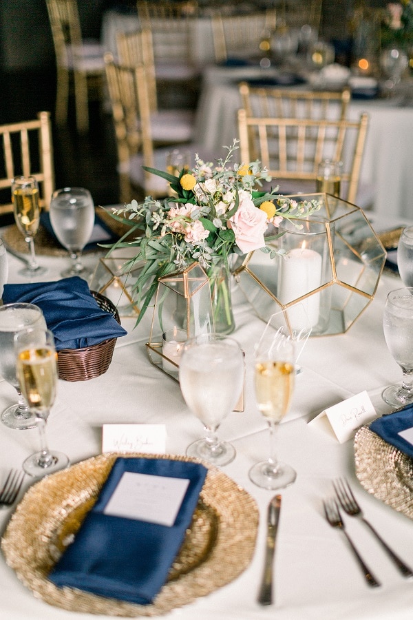 table setting with gold chairs, chargers and navy accents by A Chair Affair Inc.