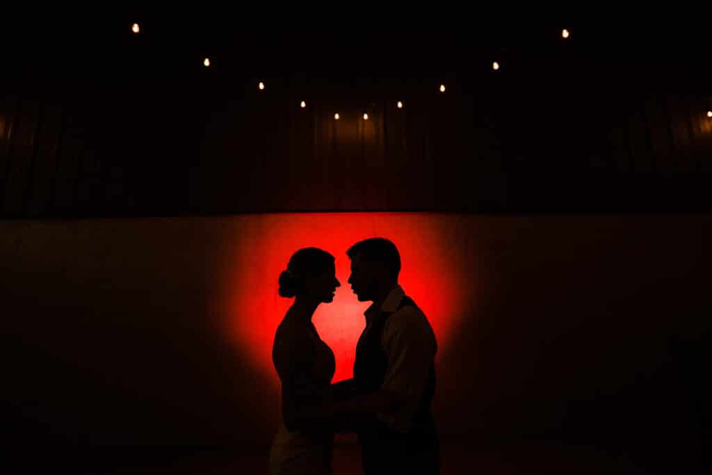 couple silhouetted in red light by Roy Serafin Photo Company