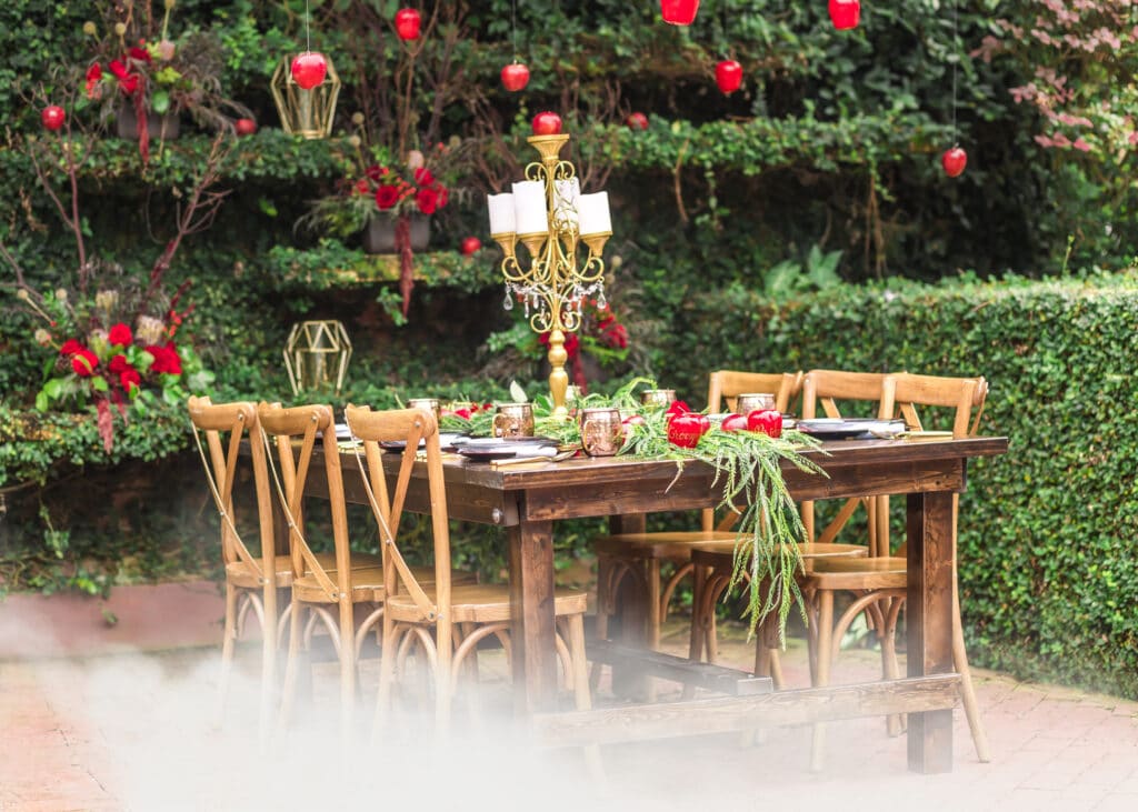 wedding reception table in a garden with candelabra centerpiece and table runner of greenery details by Emotions 360