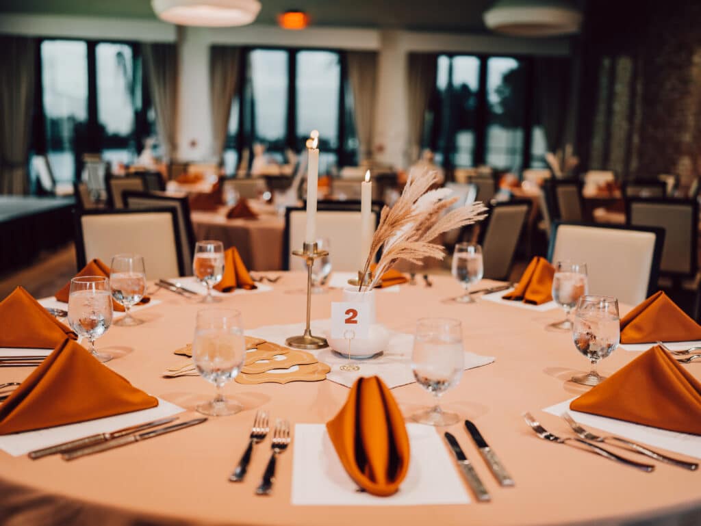 wedding reception table with sherbet table cloth and orange napkins at Dockside Lake Nona