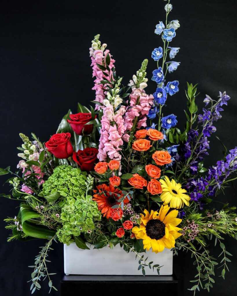 rainbow colored floral arrangement by Leaf & Blossom Co.