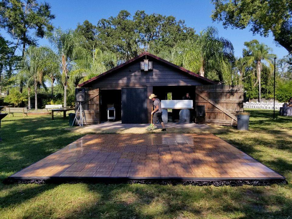 outdoor wooden dance floor from Stages Plus in Central Florida in front of wooden building