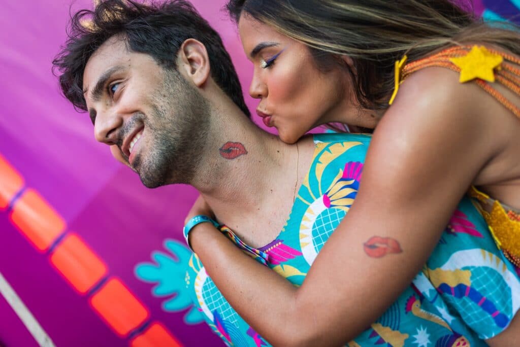 temporary kissing tattoo on man's neck as women pretends to leave her lipstick mark by MyBooth Service