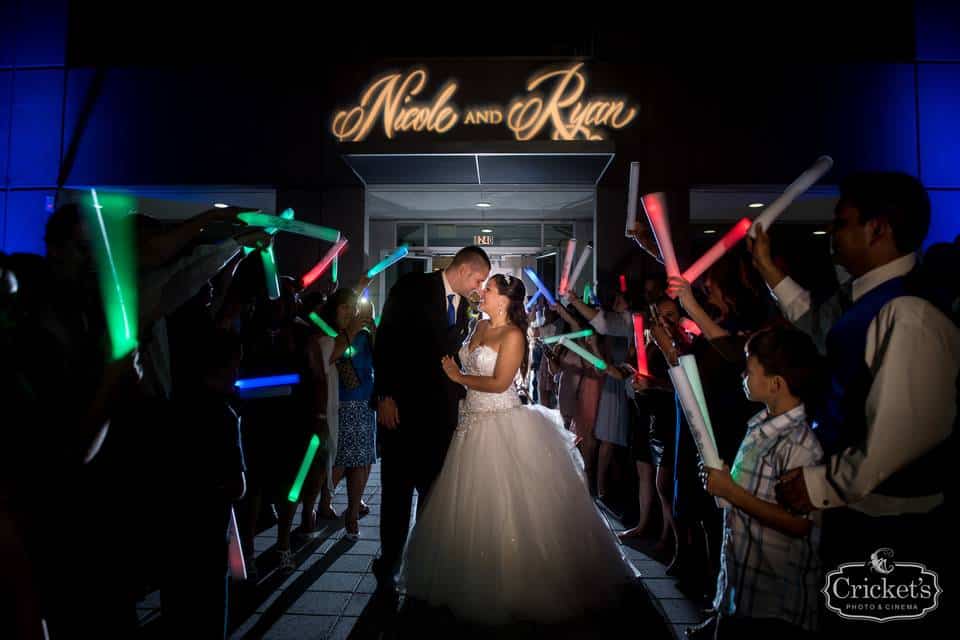 couple kissing under neon sign of their names and light saber arch by Meisner Productions