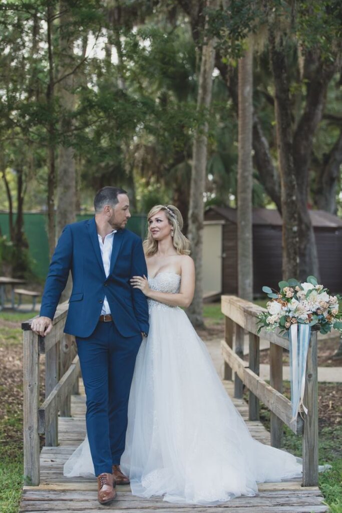 bride and groom posing on a wooden walkway at the Central Florida Zoo & Botanical Gardens