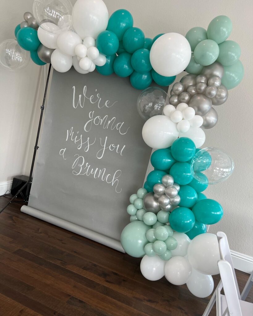 shades of turquoise and gray ballon arch on welcoming sign by Fab and Float events