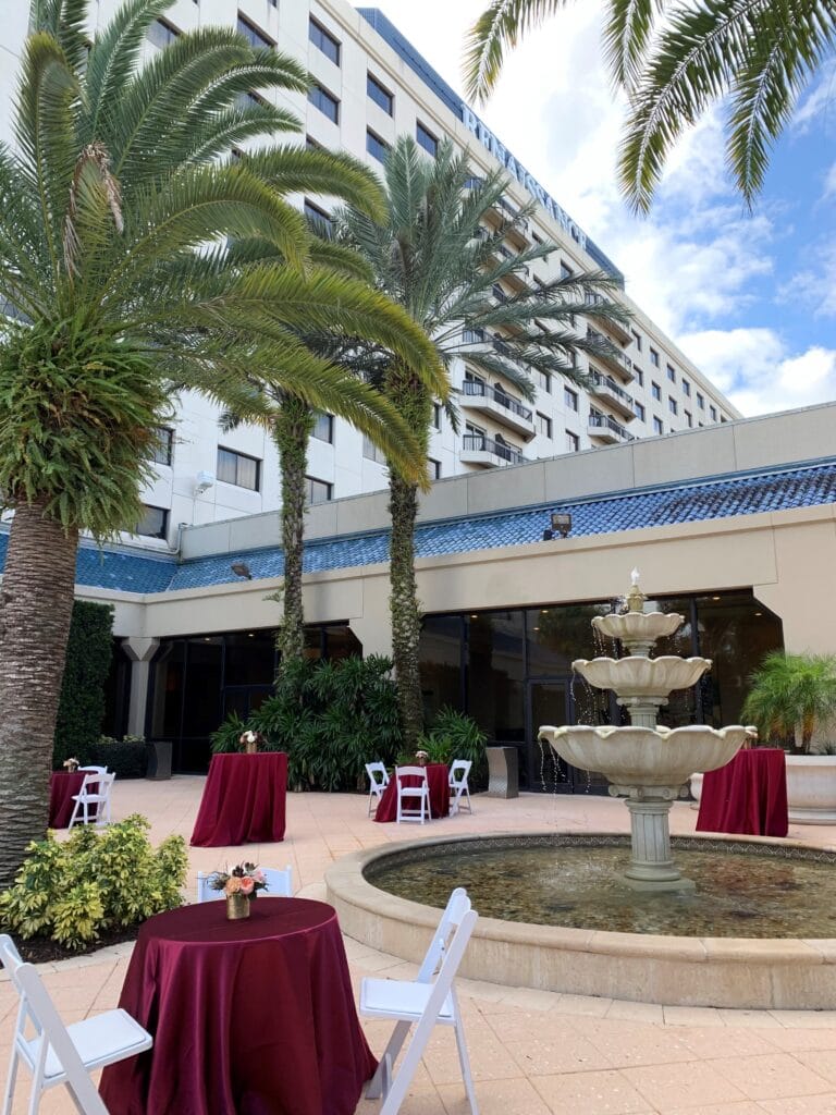 Renaissance Orlando set up for a reception after a wedding ceremony. There are white chairs and maroon linens