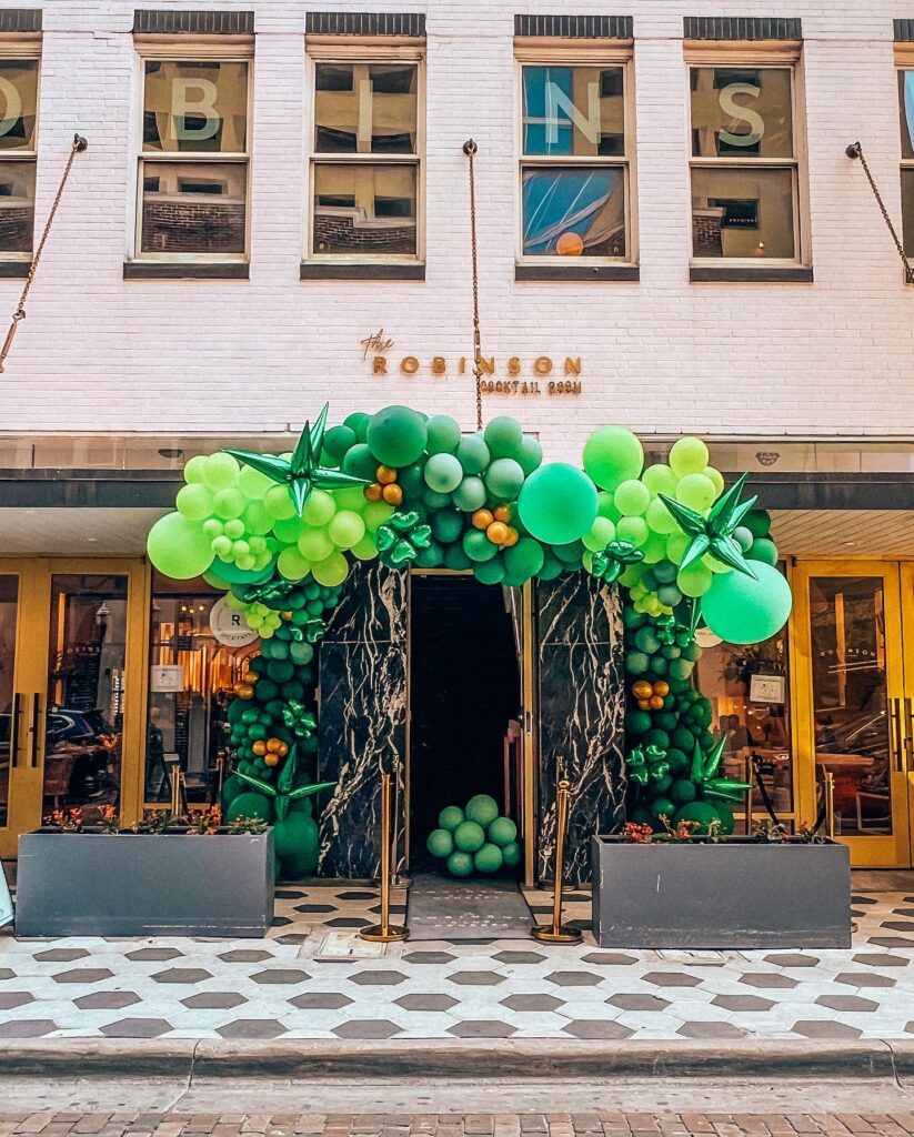 green balloons make welcoming tree to walk under for front of restaurant by Fab and Float events