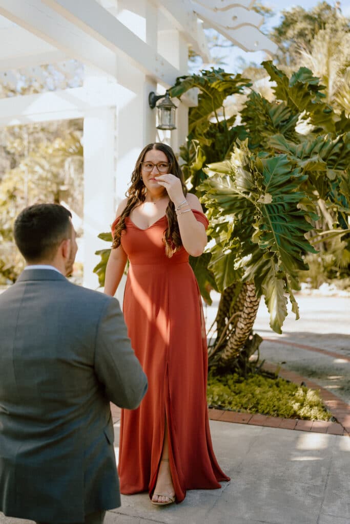 woman in orange maxi dress surprised by Botanical Gardens Marriage Proposal