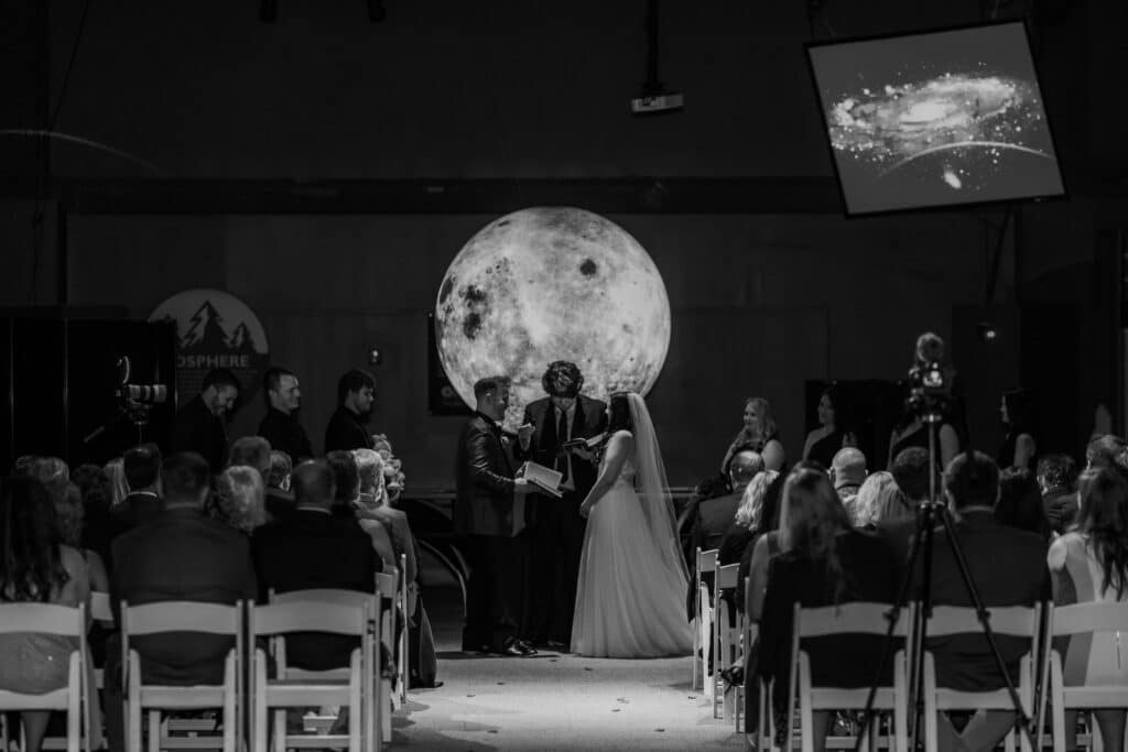 Wedding ceremony set up in the Orlando Science Center in front of a projection of the moon