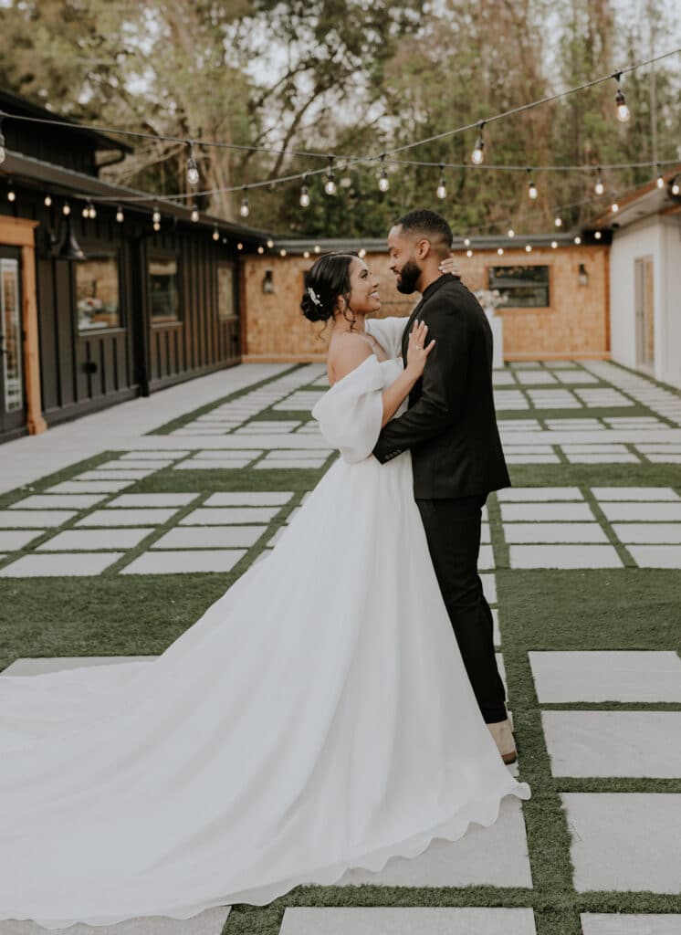 bride and groom kissing in courtyard of The Black Barn