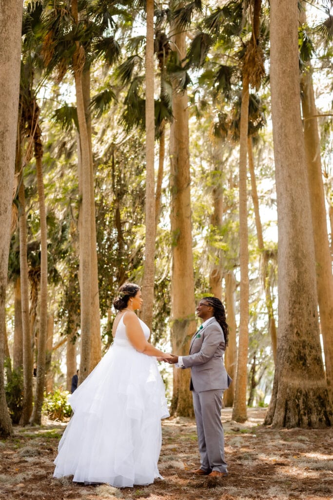 bride and groom smiling and holding hands for a private moment in the woods photo by SMO Photography