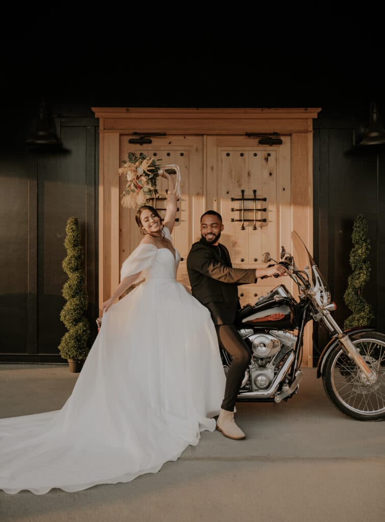 bride and groom on a motorcycle leaving wedding venue at The Black Barn