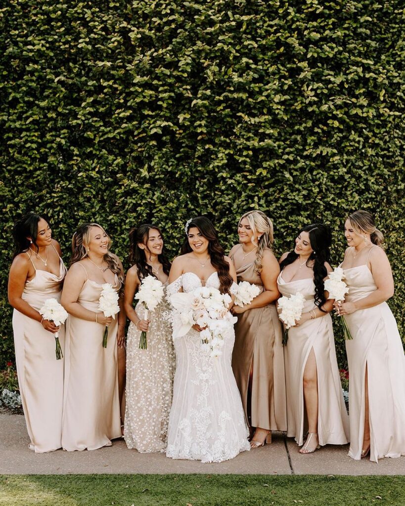 bridesmaids in shades of champagne with bride all holding white bouquets from In Bloom Florist
