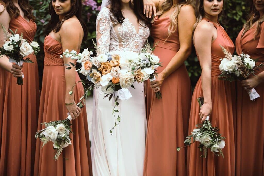 bride and bridesmaids in dusty orange at event planned by Just Save the Date