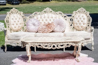 elaborate white sofa and coffee table with pink rug by Making It Matthews