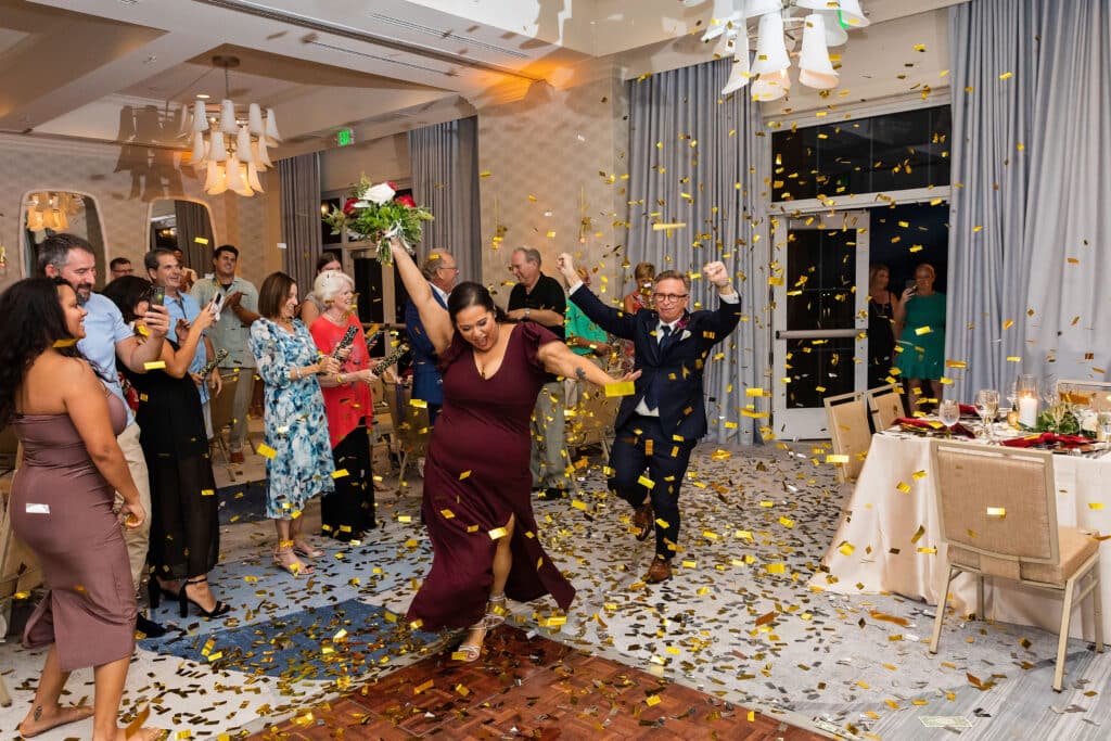 confetti falling on woman who caught bridal bouquet at event planned by Just Save the Date