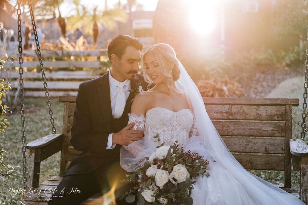 bride and groom posing on a bench at the golden hour coordinated by SMS Events & Design