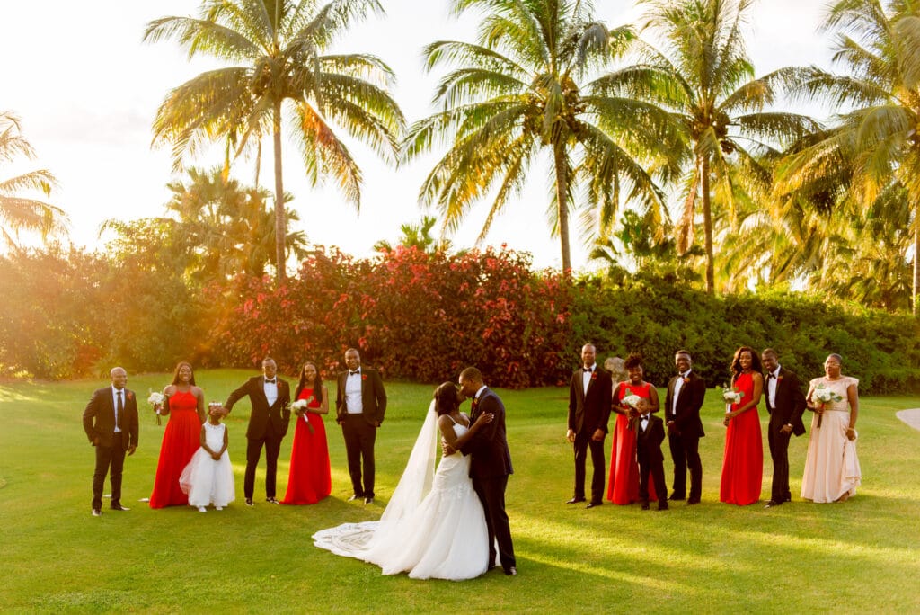 wedding party in red and black attire in tropical garden by Sydney Morman Photography