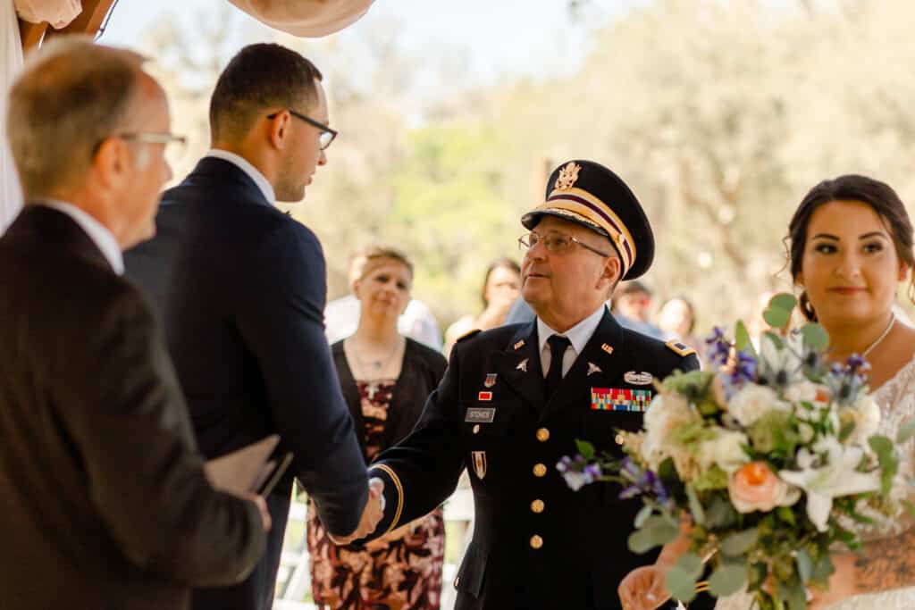 groom shaking the hand of the father of the bride with officiant by Classically Cool Event Productions