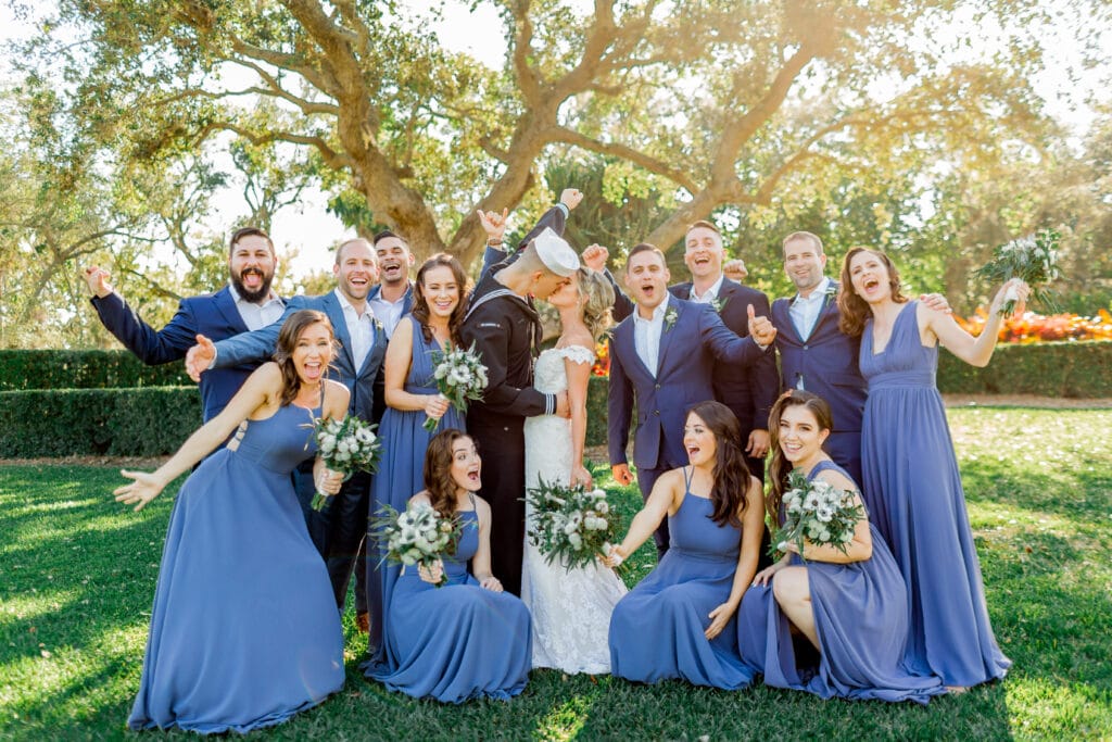 sailor kisses his bride surrounded by wedding party in blues by Sydney Morman Photography