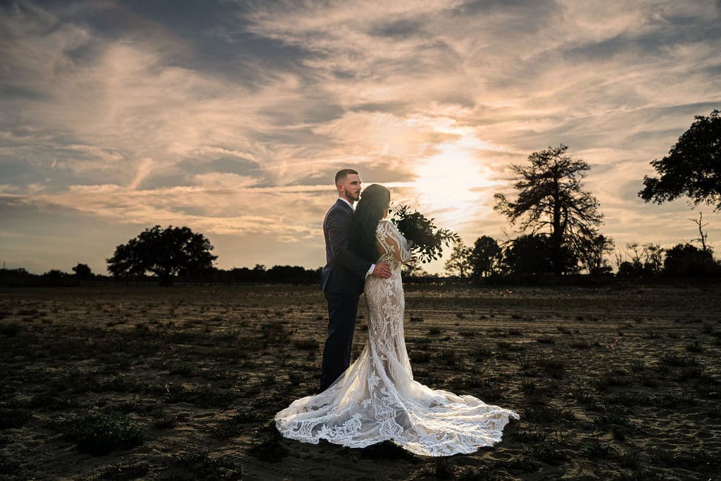 bride and groom posing against a sunset sky in the golden hour coordinated by SMS Events & Design