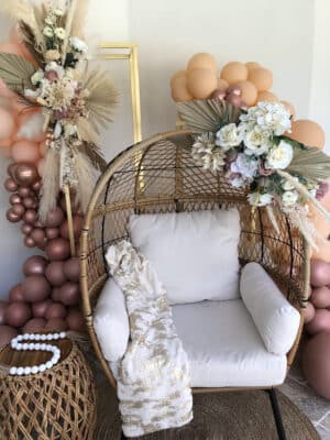 rattan chair and coffee table with gold and pumpkin accents and rafia by Making It Matthews