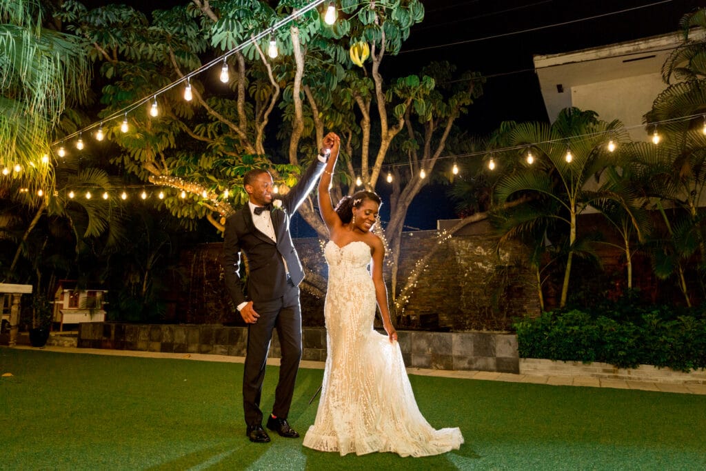 bride and groom share a dance and twirl under market lights by Sydney Morman Photography
