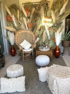 Wicker chairs with macrame accents and greenery behind