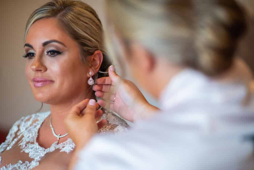 bride having her accessories put on, photo from Weddings By Ray