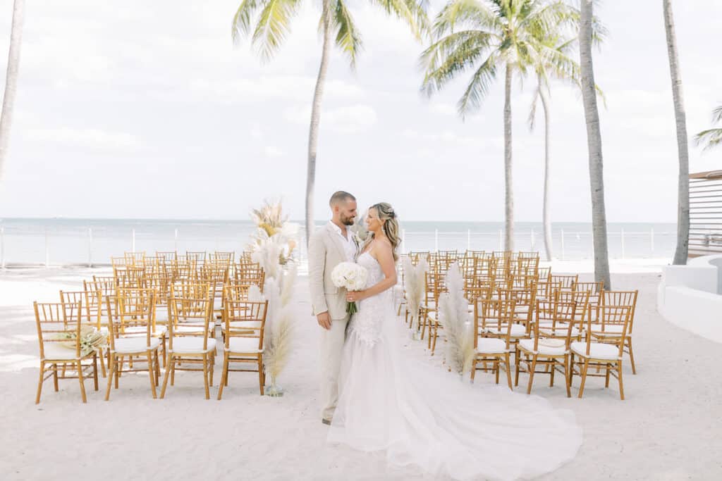 bride and groom standing at beach wedding ceremony site at event planned by Just Save the Date