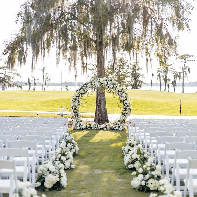outdoor wedding aisle and arch filled with flowers from In Bloom Florist